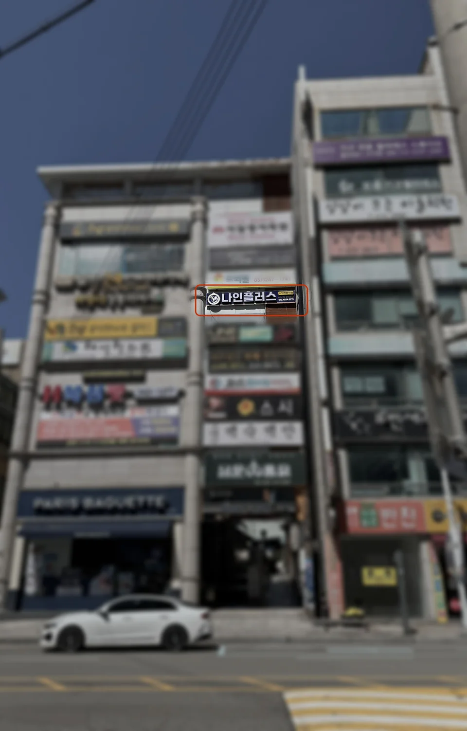 나인플러스학원이 입주한 건물 전체 사진. 다른 층 간판들은 흐리게 처리되고 나인플러스 간판만 선명하게 강조되어 붉은 테두리로 표시되어 있다