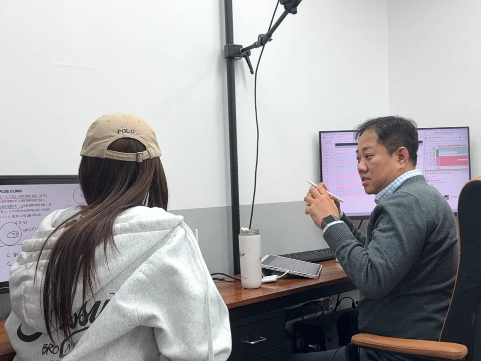 학생과 이태훈 원장이 클리닉 문제 화면을 함께 보며 일대일로 질의응답하는 모습